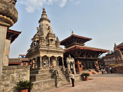 Kamenn� hinduistick� chr�m Siddhi Lakshmi v indickom architektonickom �t�le Shikhara so sochami str�nych slonov a levov na schodisku stojaci ved�a drevenej viacstup�ovej pagody na n�mest� Bhaktapur Durbar Square v Nep�le.