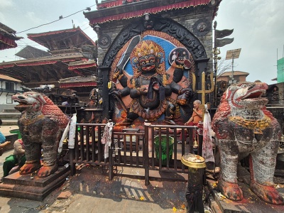 Monument�lny kamenn� reli�f hroziv�ho hinduistick�ho bo�stva Kala Bhairava s me�om a od�atou hlavou v ruk�ch, str�en� dvoma kamenn�mi levmi na n�mest� Kathmandu Durbar Square v Nep�le.