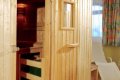 Otvoren� dreven� sauna s lavicami a svetl�m le�adlom pri okne