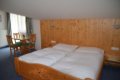 Dreven� man�elsk� poste� s bielou prikr�vkou a jed�lensk� st�l pri okne