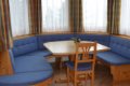 Modr� �al�nen� lavica okolo stola pod oknami s farebn�mi z�vesmi