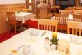 Prestret� stoly s bielymi obrusmi a dreven� stoli�ky v jed�lni