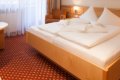 Dvojl��kov� poste� s bielou bieliz�ou a posedenie pri okne so z�vesmi