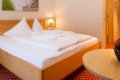 Izba s drevenou poste�ou, kreslom a okr�hlym stol�kom s rastlinou