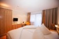 Sp�l�a s bielou poste�nou bieliz�ou, drevenou skri�ou a telev�zorom
