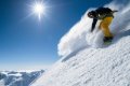 Snowboardista v �lt�ch nohaviciach v�ri pra�an na strmom slne�nom svahu