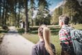 �ena a mu� s batohom pri ceste medzi stromami s chatkou v pozad�