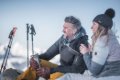 Mu� s termoskou a �ena s poh�rom oddychuj� v snehu ved�a turistick�ch pal�c