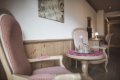 Kresl� s �erven�m k�rovan�m pri okr�hlom stol�ku pod dekor�ciou s notami