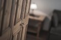 Dreven� dvierka skrine s kovov�mi �chytkami a lampa v pozad�