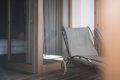 Siv� le�adlo na drevenej terase pri otvoren�ch presklen�ch dver�ch