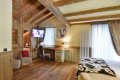 Izba s poste�ou, kreslami, telev�zorom a stolom pod oknom