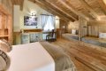 Podkrovn� izba s man�elskou poste�ou, �al�nen�mi lavicami a p�sac�m stolom