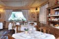 Re�taur�cia s dreven�m obkladom, prestret�mi stolmi a policou s riadom