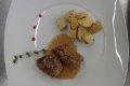 K�sky m�sa v hnedej om��ke so zemiakmi a vetvi�kou bylinky