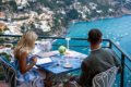 Dvojica pri prestretom stole na terase s v�h�adom na Positano a z�liv