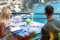 Dvojica pri prestretom stole na terase nad morom a pobre�nou z�stavbou