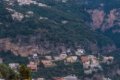 Domy na strm�ch zelen�ch svahoch pod skaln�mi stenami a osvetlen� terasa