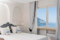 Biela izba s dvojl��kom a oknom s v�h�adom na more a skalnat� pobre�ie