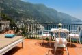 Terasa s bielym stolom, stoli�kami a le�adlom nad morom a pobre��m