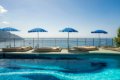 Vonkaj�� baz�n s le�adlami a modr�mi slne�n�kmi pred morsk�m horizontom