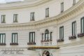 Obl�kov� biela fas�da hotela so zelen�mi okenicami a kvetmi pod oknami