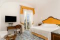 Sp�l�a so �lt�m �elom postele, p�sac�m stolom a modro-�ltou dla�bou