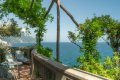 Terasa s pr�ten�m seden�m, kamennou balustr�dou a v�h�adom na more