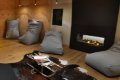 Siv� sedacie vaky pri krbe, dreven� obklad a sane s �asopismi na ko�i