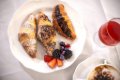 Croissanty s bobu�ov�m ovoc�m na bielom tanieri ved�a k�vy a �erven�ho n�poja