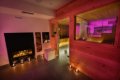 Vstup do drevenej sauny ved�a krbu, ulo�enej z�soby dreva a svie�ok
