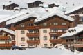 Hotel Astoria s dreven�mi balk�nmi a zasne�en�mi strechami pod svahom