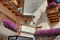 Detail vstupu do hotela s dreven�mi balk�nmi a bohat�mi fialov�mi kvetmi