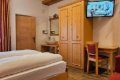 Izba s dvojl��kom, drevenou skri�ou, p�sac�m stolom a um�vadlom