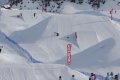 Snowpark so snehov�mi skokmi, modr�mi sie�ami a skupinou snowboardistov