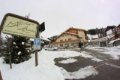 Hotelov� budova s balk�nmi, ozna�en�m pri ceste a zasne�en�m parkoviskom