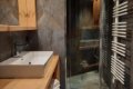 K�pe��a s hranat�m um�vadlom, presklenou sprchou a bielym radi�torom