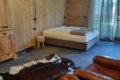 Izba s dvojl��kom, drevenou komodou, ko�en�m seden�m a ko�ou na podlahe