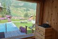 Dreven� sauna s pecou a ve�k�m oknom smerom k baz�nu, z�hrade a hor�m
