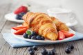 Croissanty s jahodami a �u�oriedkami na bielom tanieri ved�a ��lky