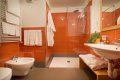 K�pe��a s oran�ov�m obkladom, presklenou sprchou, bidetom a um�vadlom