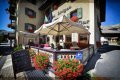 Terasa pred Hotelom Livigno so slne�n�kom, seden�m a �erven�mi kvetmi