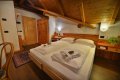 Podkrovn� sp�l�a s dvojl��kom, drevenou skri�ou a odkryt�mi tr�mami
