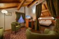 Podkrovn� izba so zelen�mi kreslami a sp�l�ou oddelenou z�vesmi